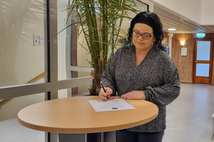 Bild på när kommunstyrelsens ordförande Marie Pettersson undetecknar Deklaration för en stark demokrati